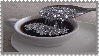 Stamp with spoon stirring glitter into coffee cup